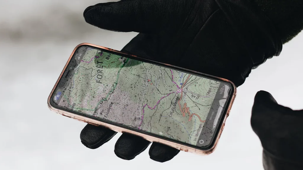 teléfono con aplicación de mapas abierta en una mano con guante