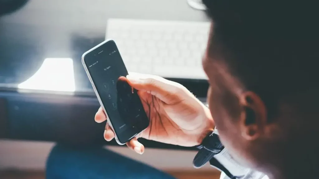 Typ, der auf sein Telefon schaut