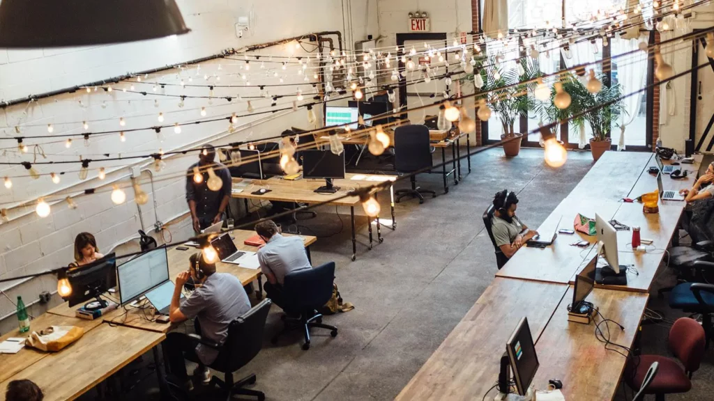 salle pleine de gens assis à des postes de travail