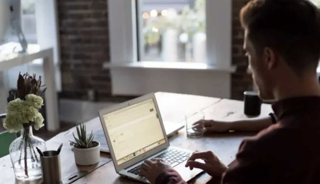 pria di kantor pusat mengetik di laptop cms