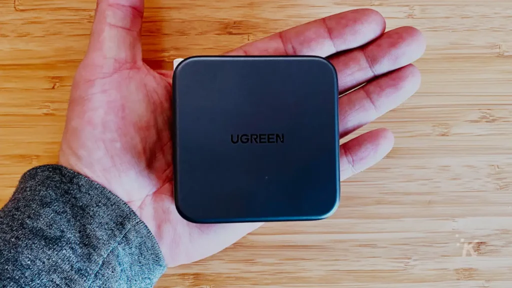 gan u green usb c wandladegerät in kevin raposos hand über einem holzschreibtisch