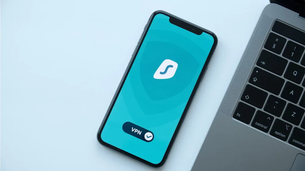 iPhone junto a una computadora portátil que muestra VPN en la pantalla