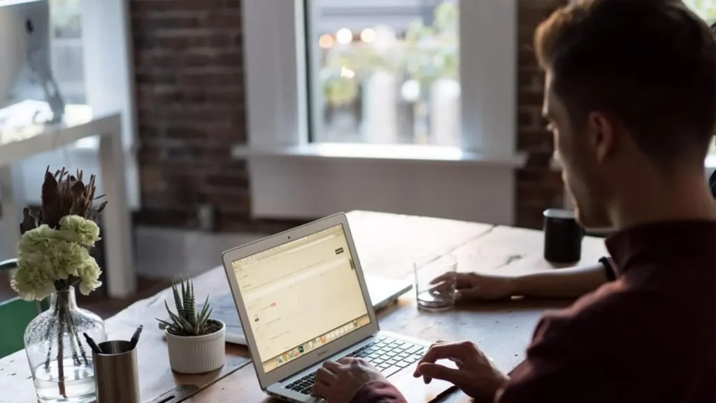 homme envoyant un e-mail sur un ordinateur portable