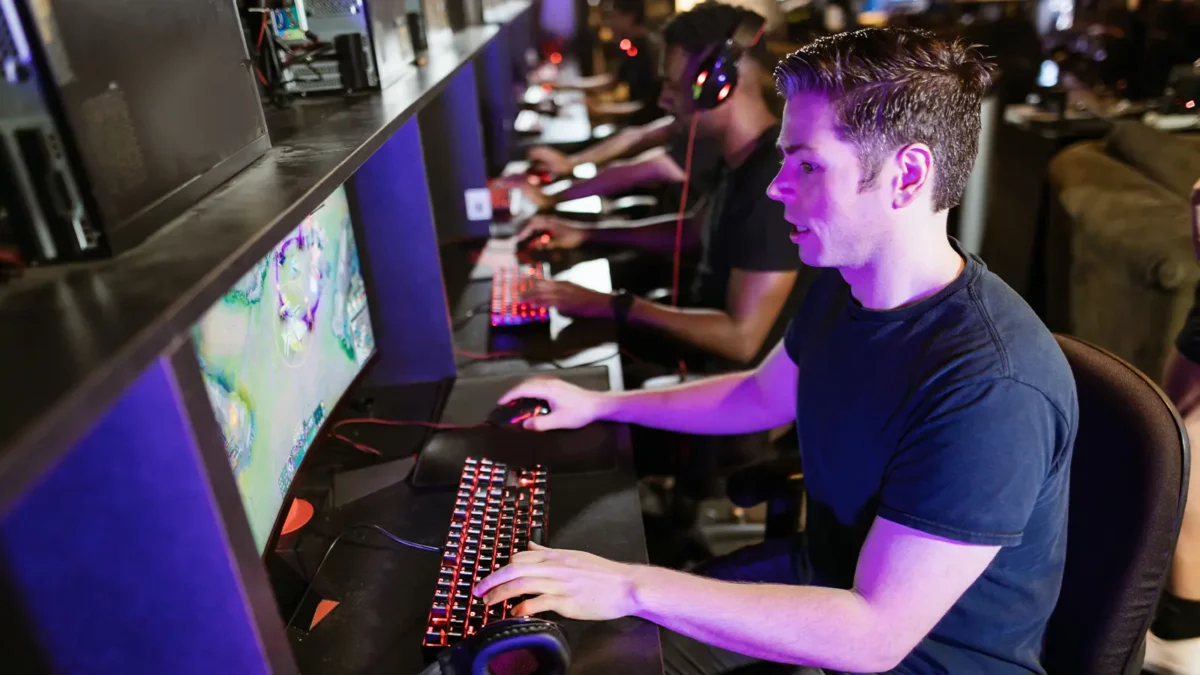 homme jouant à des jeux vidéo sur un PC avec d'autres joueurs