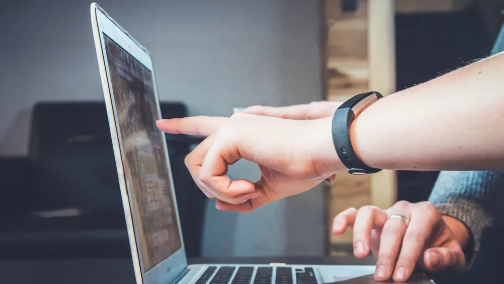 apuntando a la pantalla de la computadora portátil para clases en línea