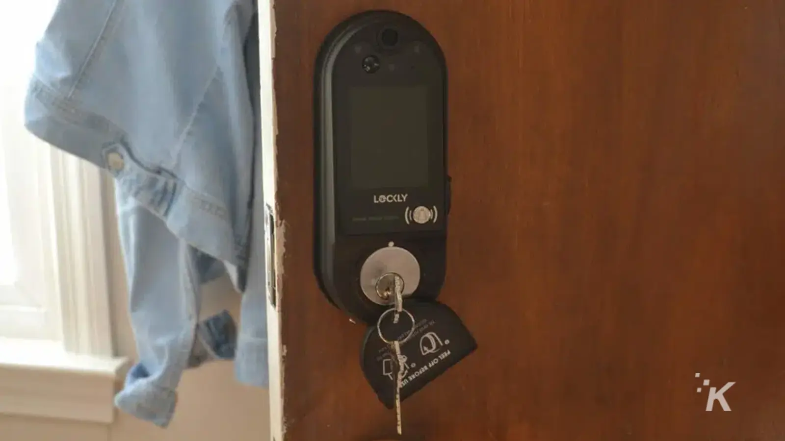 Fechadura de porta Lockly Vision Elite na porta de madeira com as chaves na fechadura.