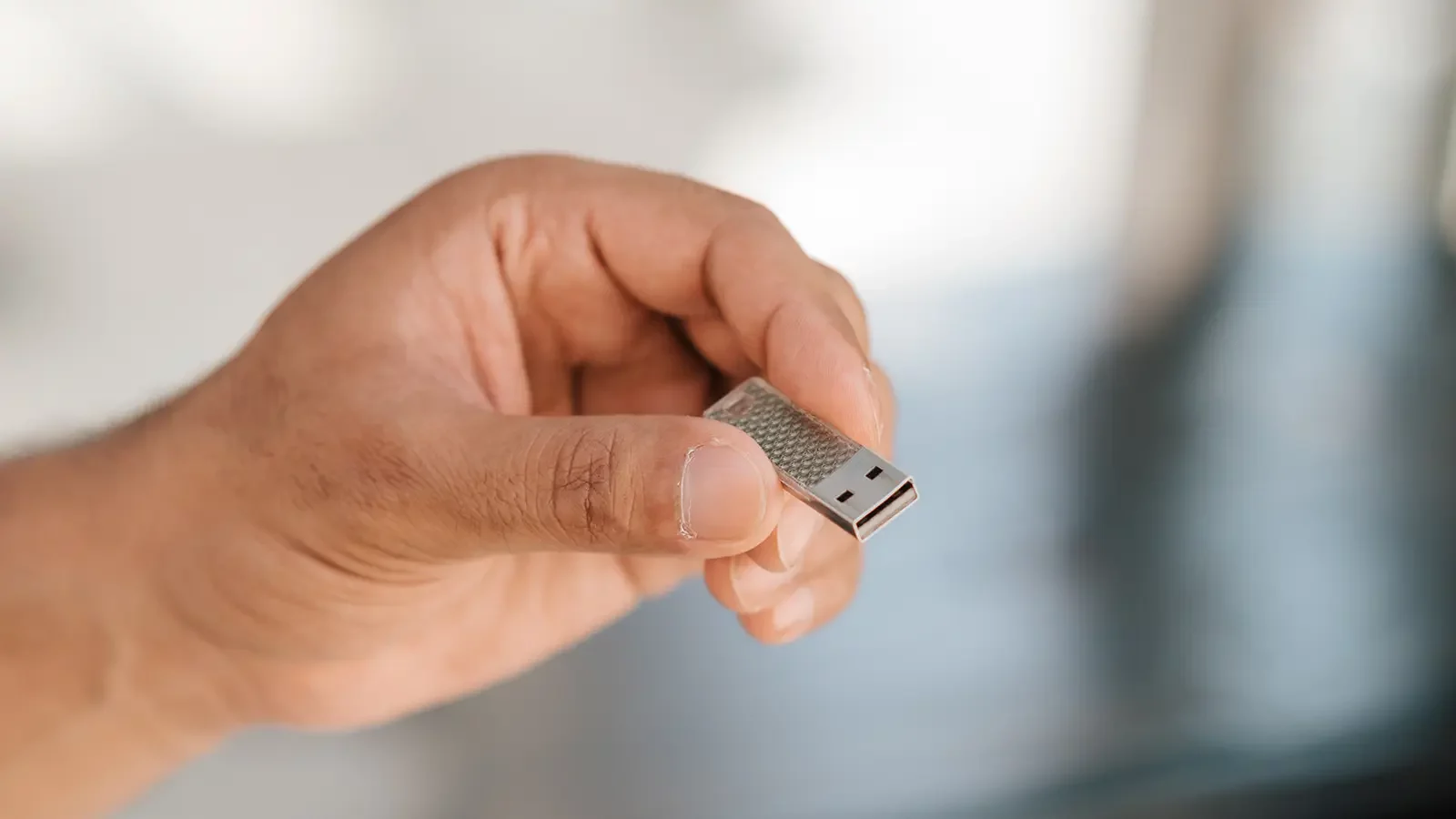 Bir USB sürücüsü tutan el