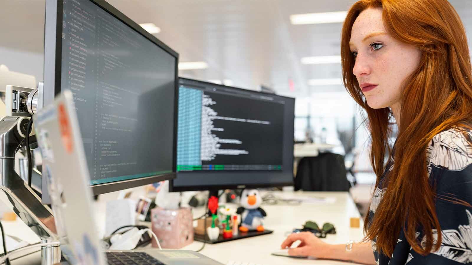 donna che guarda gli schermi dei computer con la sicurezza informatica