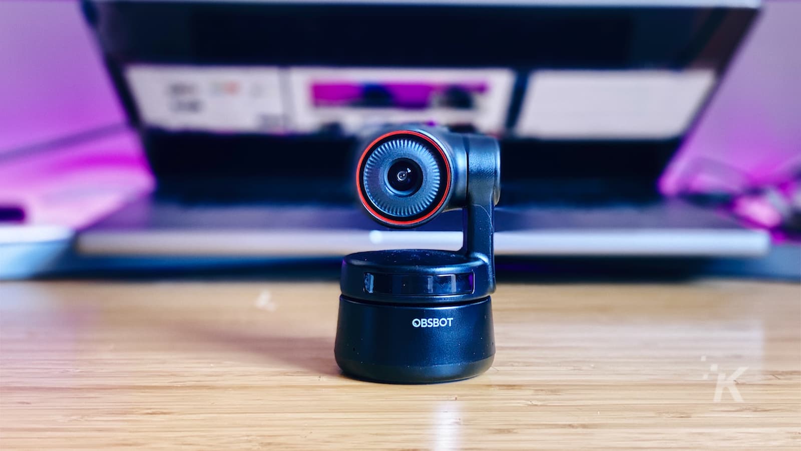 obsbot minúsculo webcam 4k sentado em uma mesa na frente do laptop meio aberto