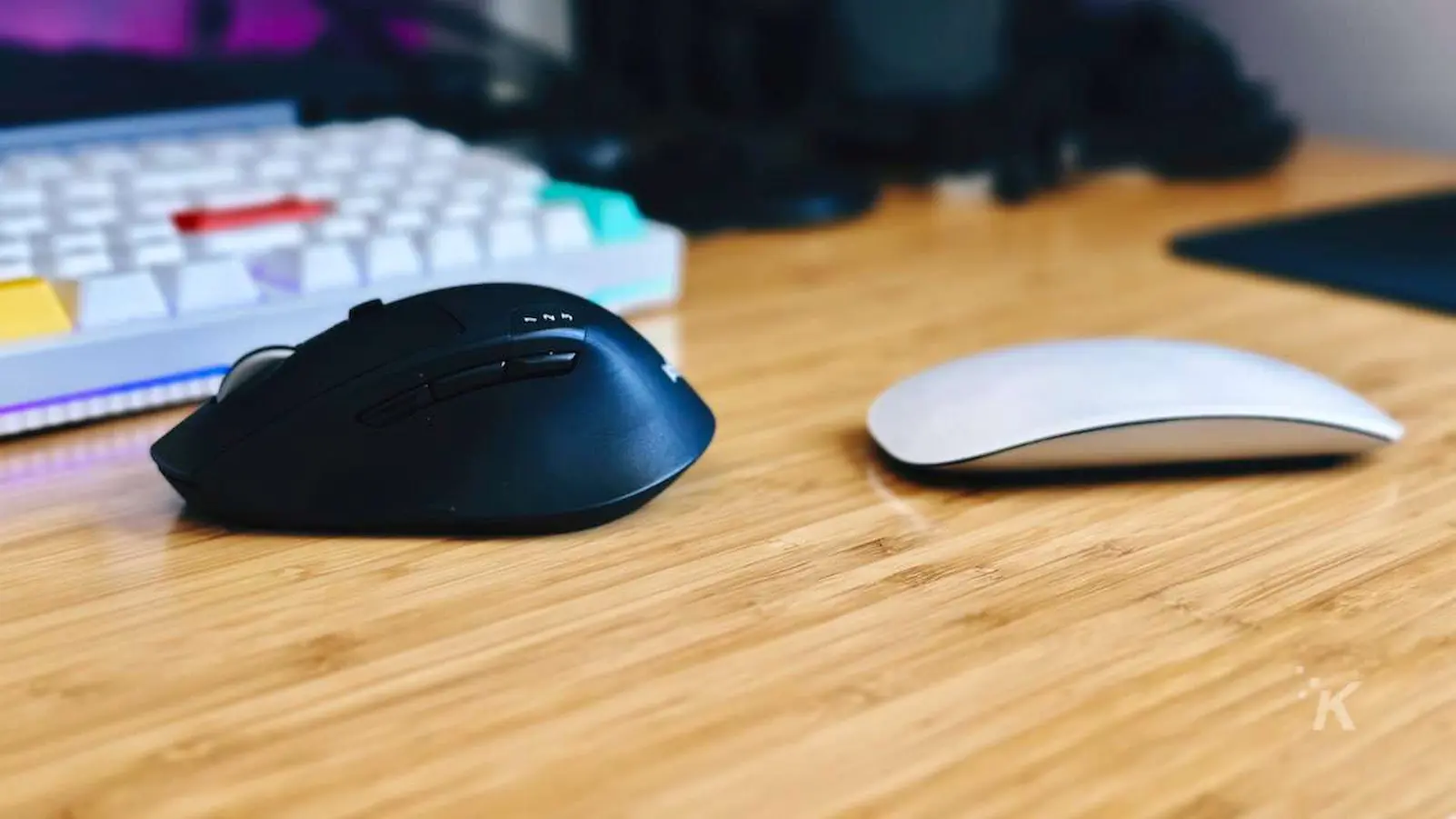 imagem lado a lado do mouse mágico da apple versus o mouse logitech m720 na mesa do escritório