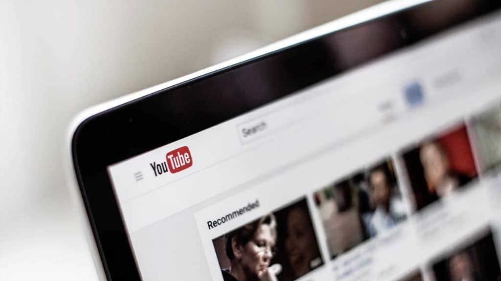 ノートパソコンに表示された YouTube のロゴで、コンテンツとチャンネル登録者が表示されています