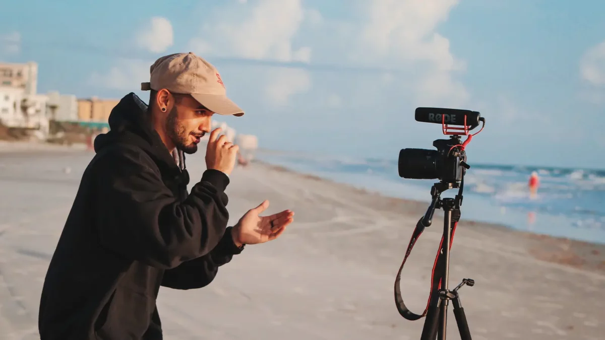 Person, die sich selbst mit einer Kamera am Strand aufzeichnet