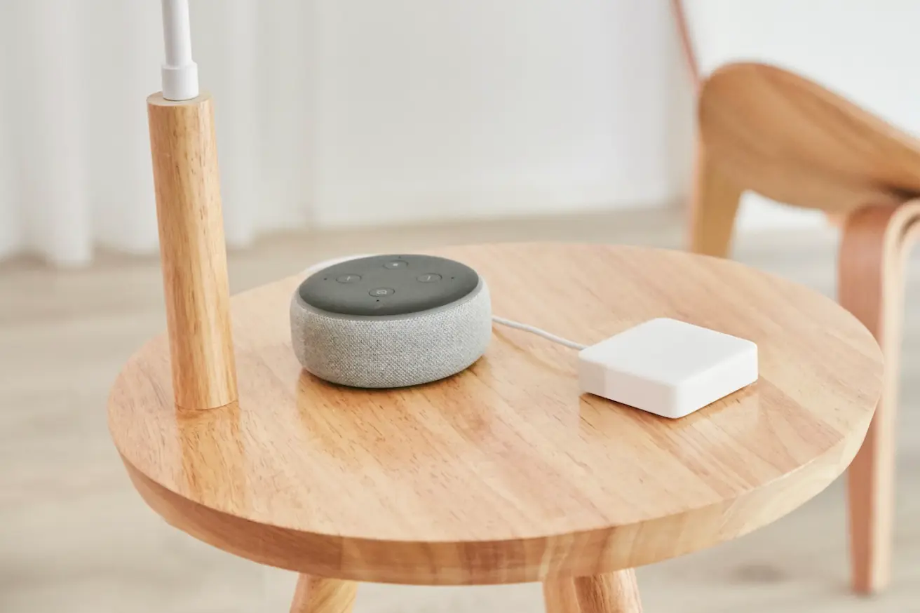 switchbot home mini hub em uma mesa de madeira perto do dispositivo echo dot like