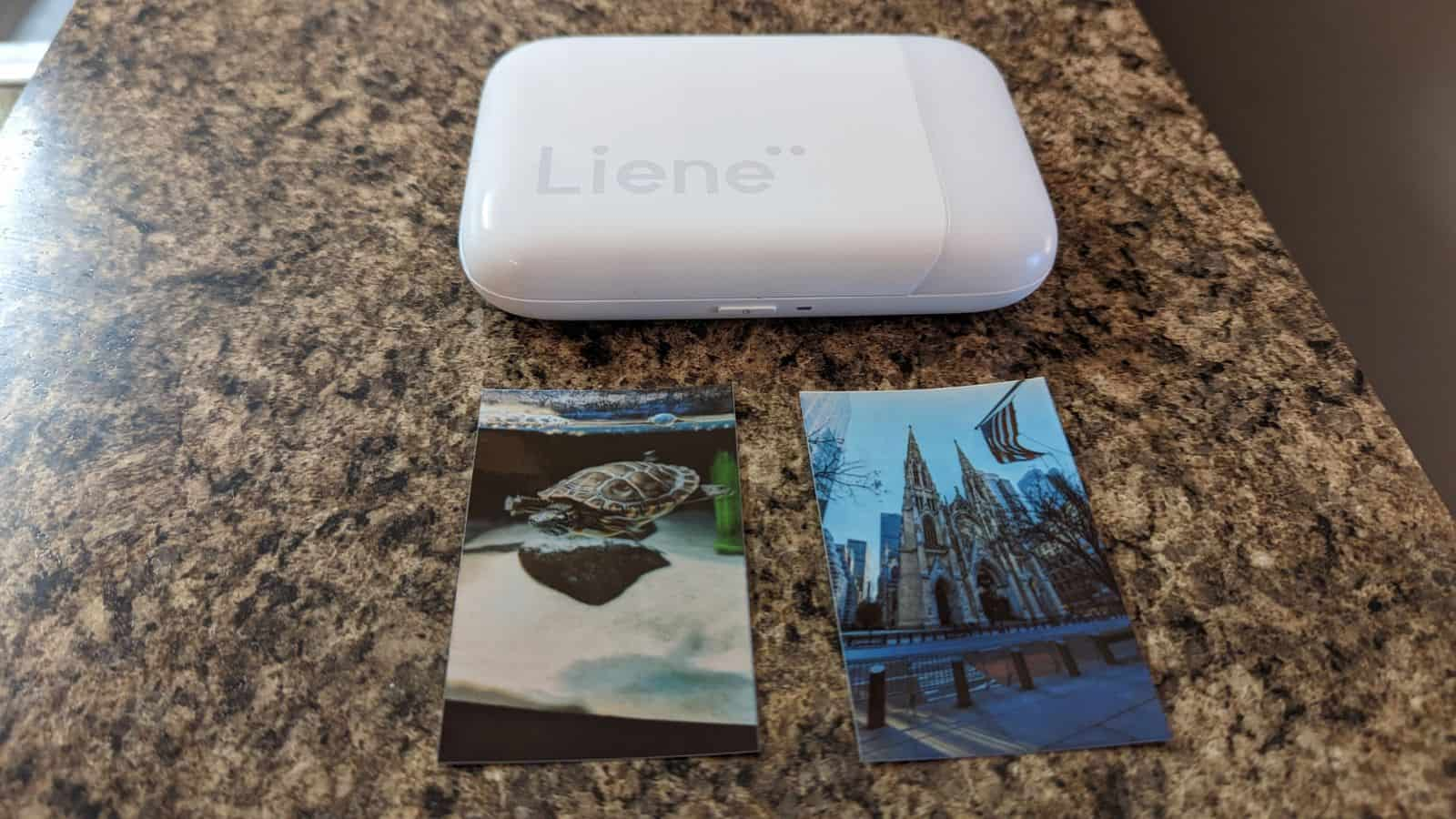 花崗岩櫃檯上的 Liene 照片打印機打印照片。