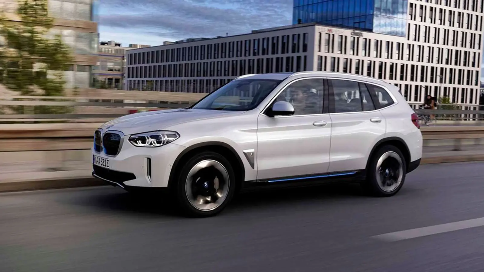 도로 위의 흰색 전기 SUV BMW iX3.