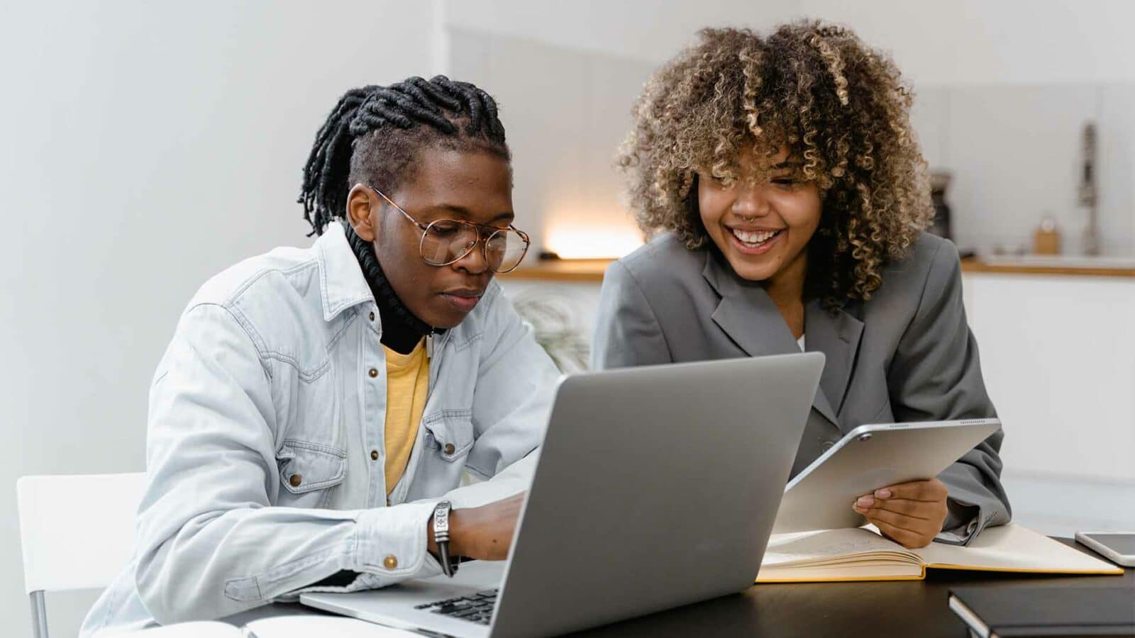 Dos personas están mirando una computadora portátil.