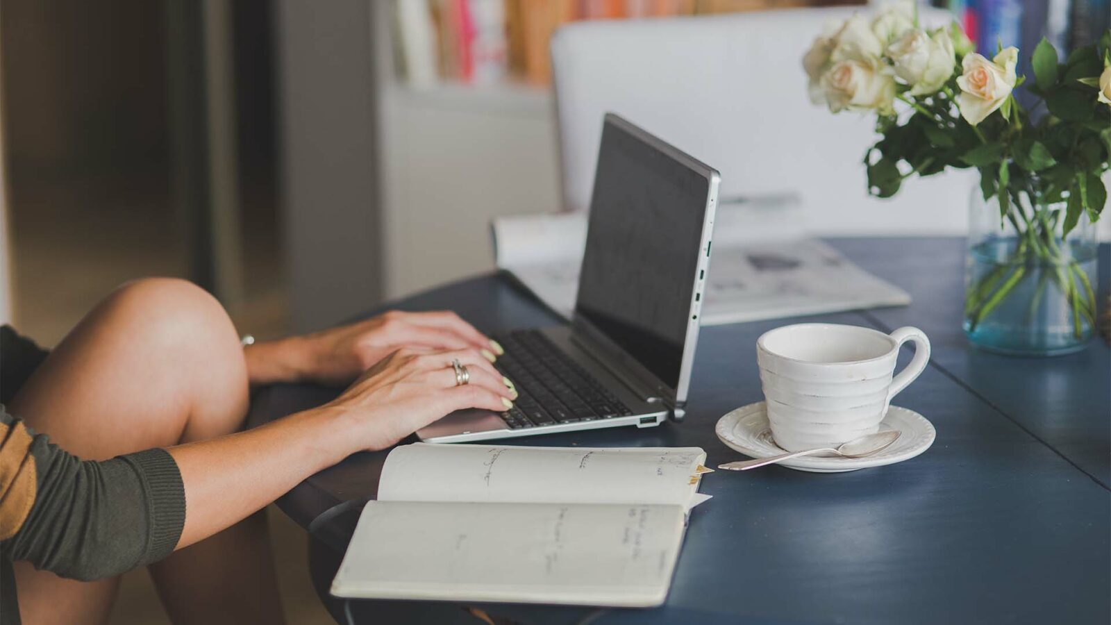 Uma pessoa está usando um laptop em uma mesa