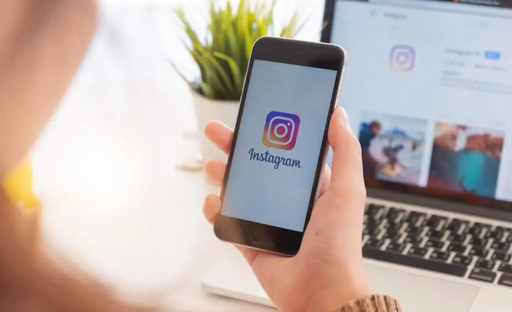 امرأة تحمل Apple iPhone مع تطبيق Instagram على الشاشة