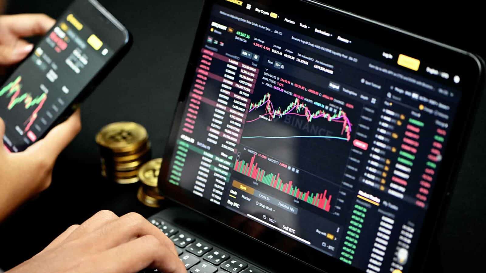 criptovaluta una persona utilizza un laptop per visualizzare uno screenshot di Markets Trade, Binance Liquid Swap e altri dispositivi elettronici sul display del computer.