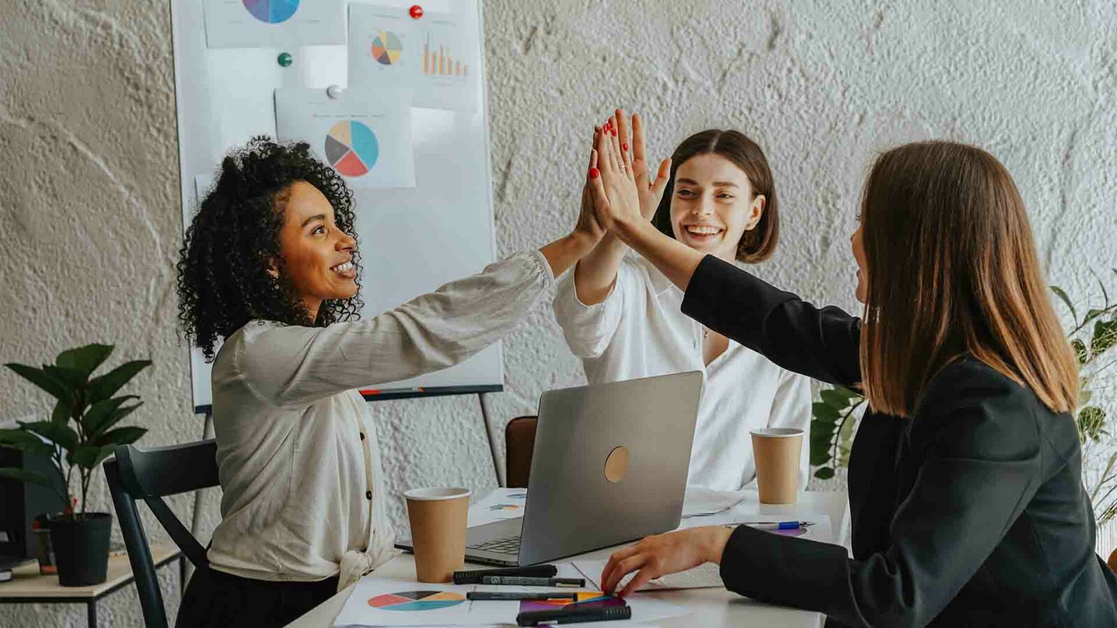 Une personne utilise un ordinateur portable alors qu'elle est entourée d'autres personnes dans un environnement intérieur.