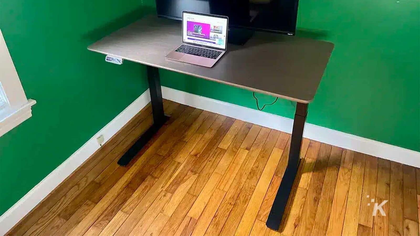 笔记本电脑放在桌子上。Flexisport E7 Premium 站立式办公桌