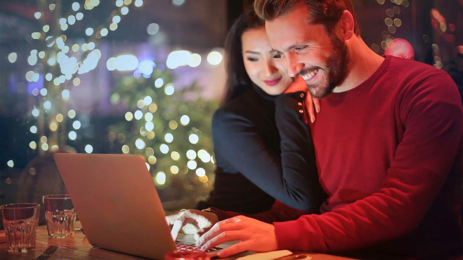 زوجان يتسوقان عبر الإنترنت على الكمبيوتر المحمول
