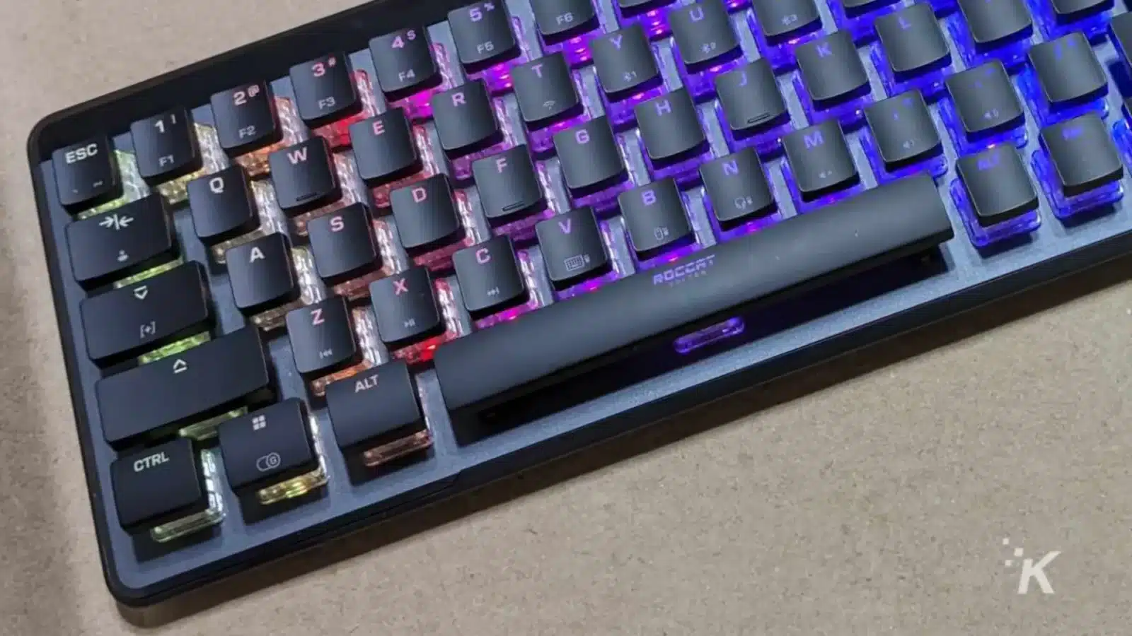 A purple computer keyboard with various levers and buttons is connected to a computer component to provide input.