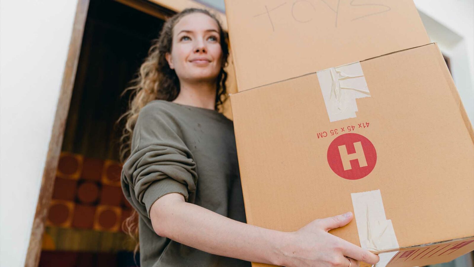 Une personne tient une boîte. L'emmener dans un self-stockage