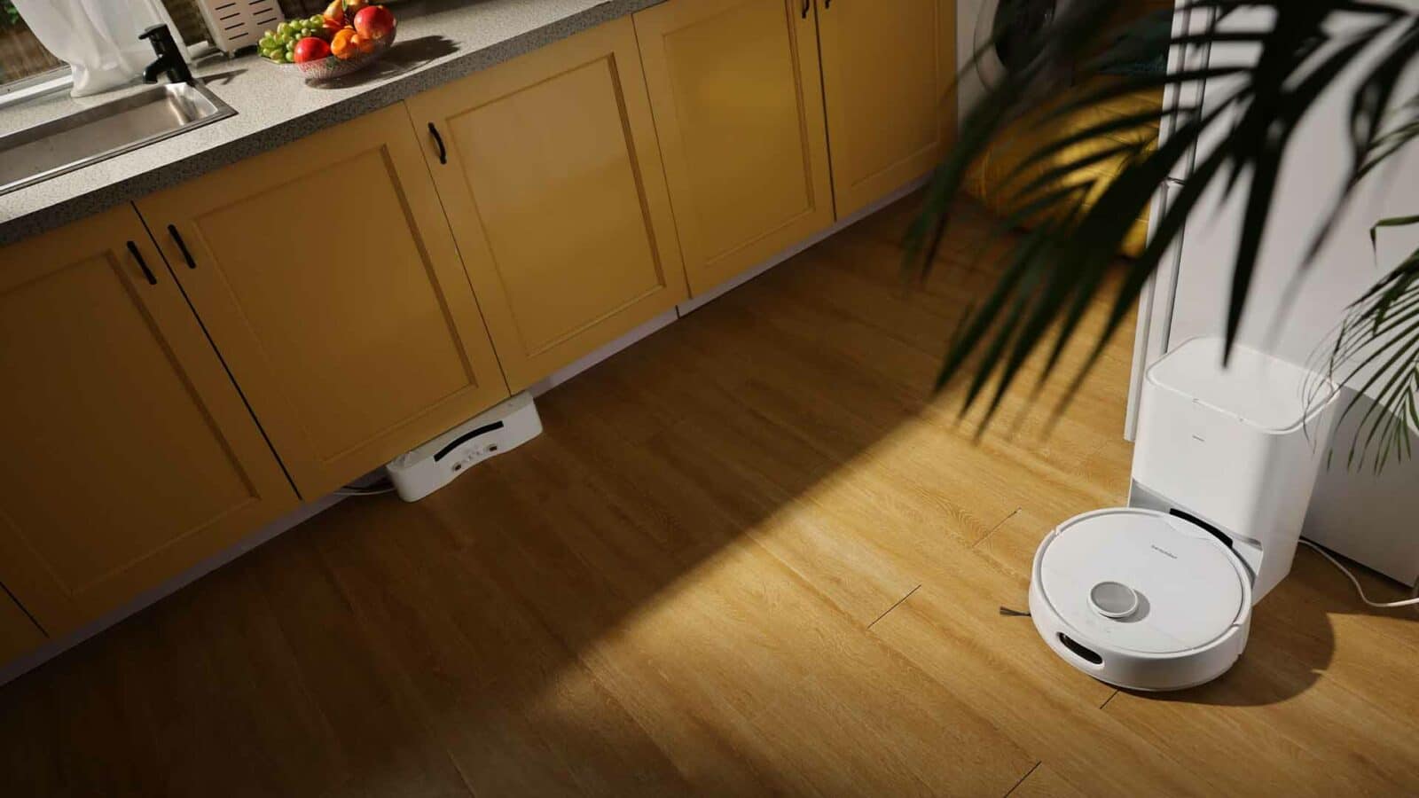 Se está remodelando la cocina, con gabinetes, encimeras, fregadero, accesorios de plomería, cajones, electrodomésticos y una planta de interior que adorna el espacio. Robot aspirador switchbot s10