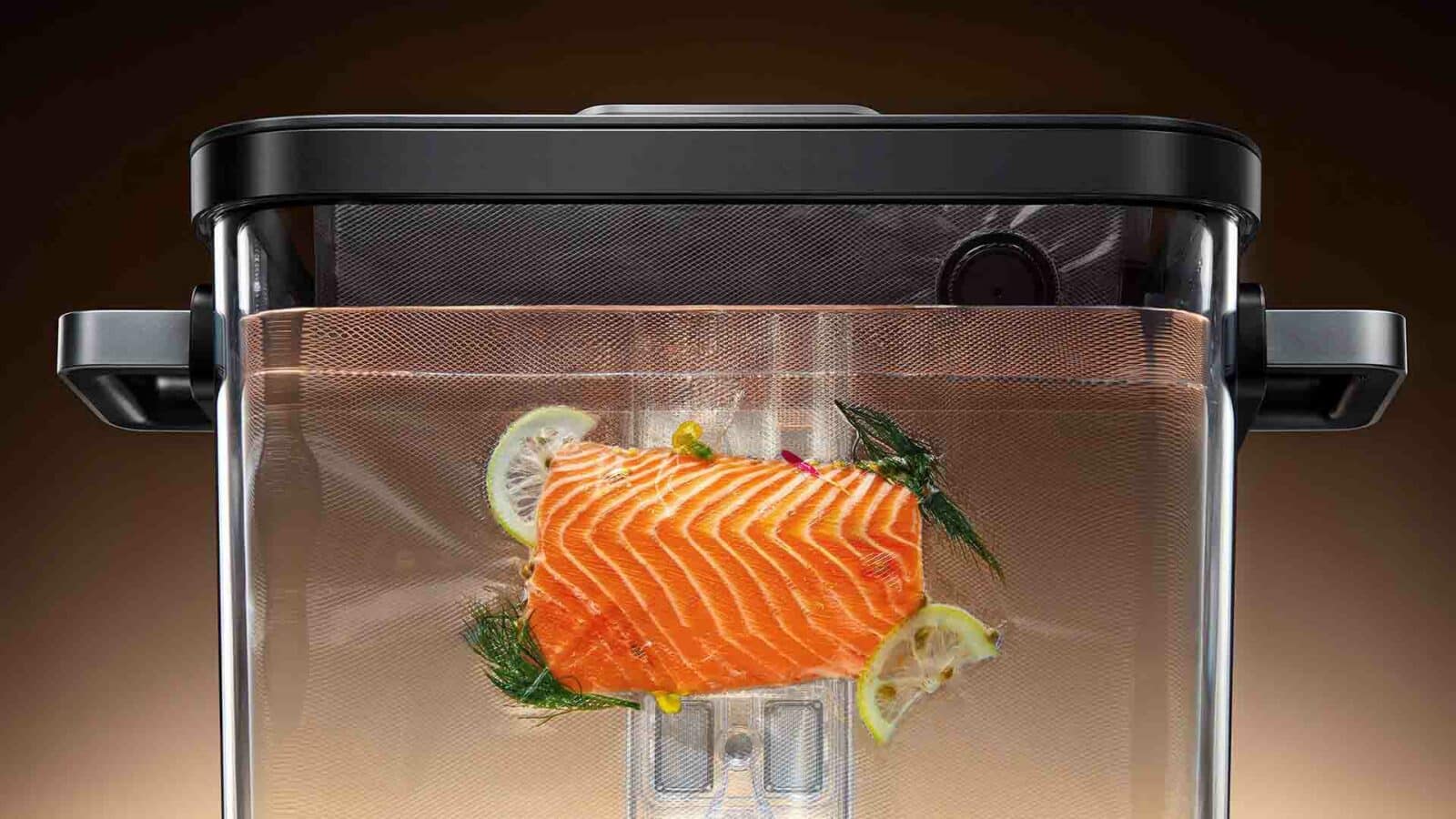 Ein großes Stück rohen Lachs liegt in einem Sous-Vide-Gerät, garniert mit Zitronenscheiben und Kräutern, bereit zum Garen mit präziser Temperaturkontrolle. Typhur Sous-Vide-Station