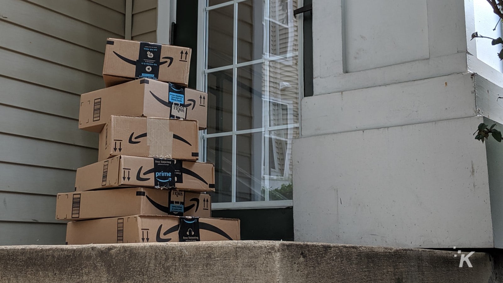 Boîtes de livraison Amazon empilées sur un porche