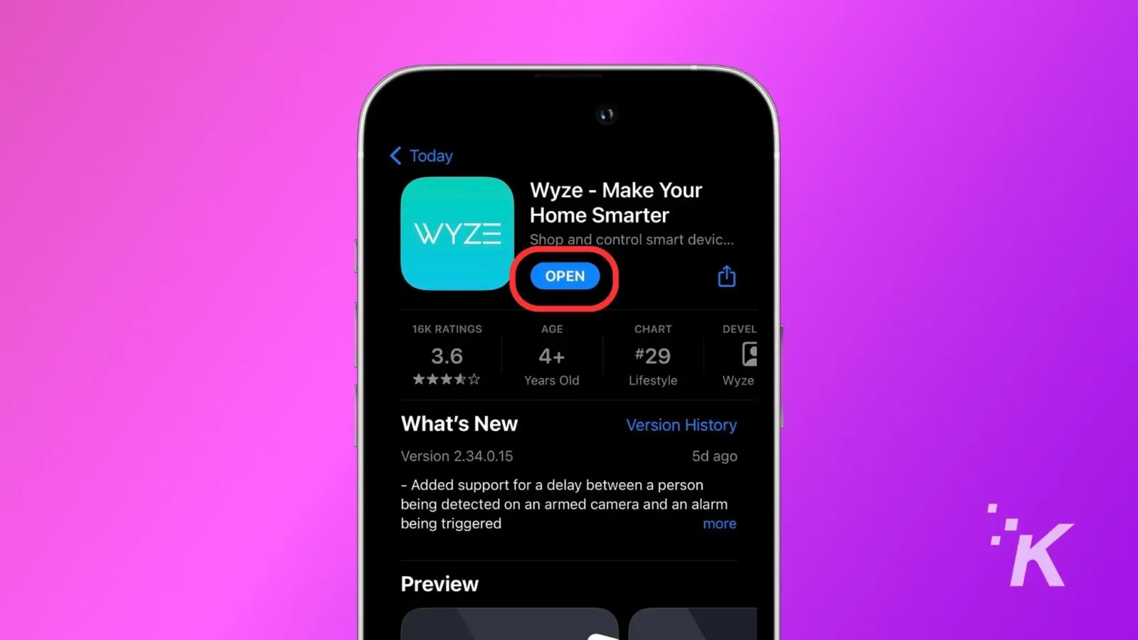 A smartphone screen displaying the wyze app page on a digital store with an "open" button highlighted. Background is solid pink with a small 'k' logo.