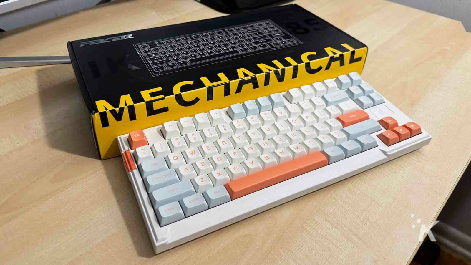 Teclado mecánico Feker plus sobre escritorio con caja.