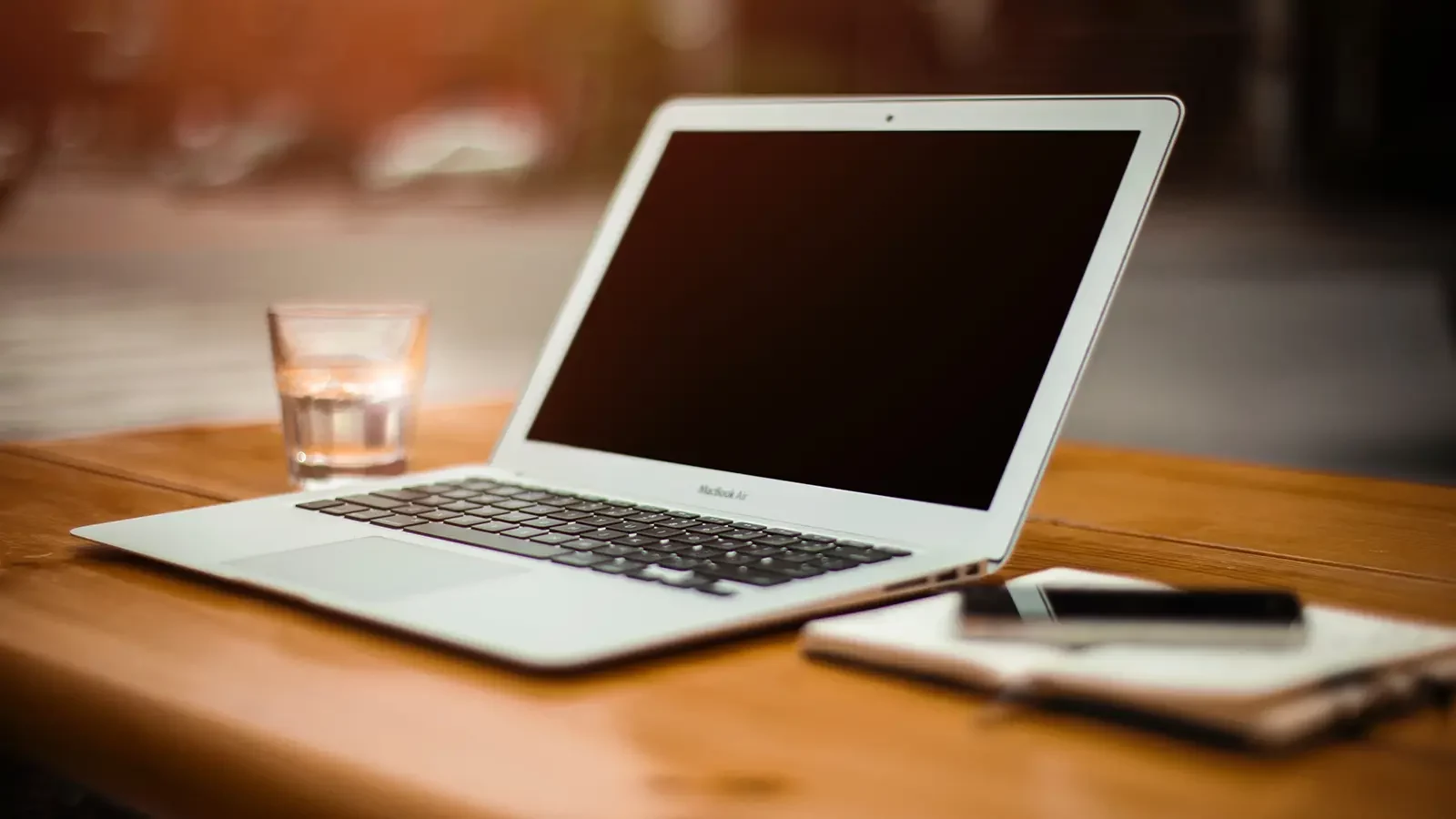 Laptop with privacy screen on a wooden desk.