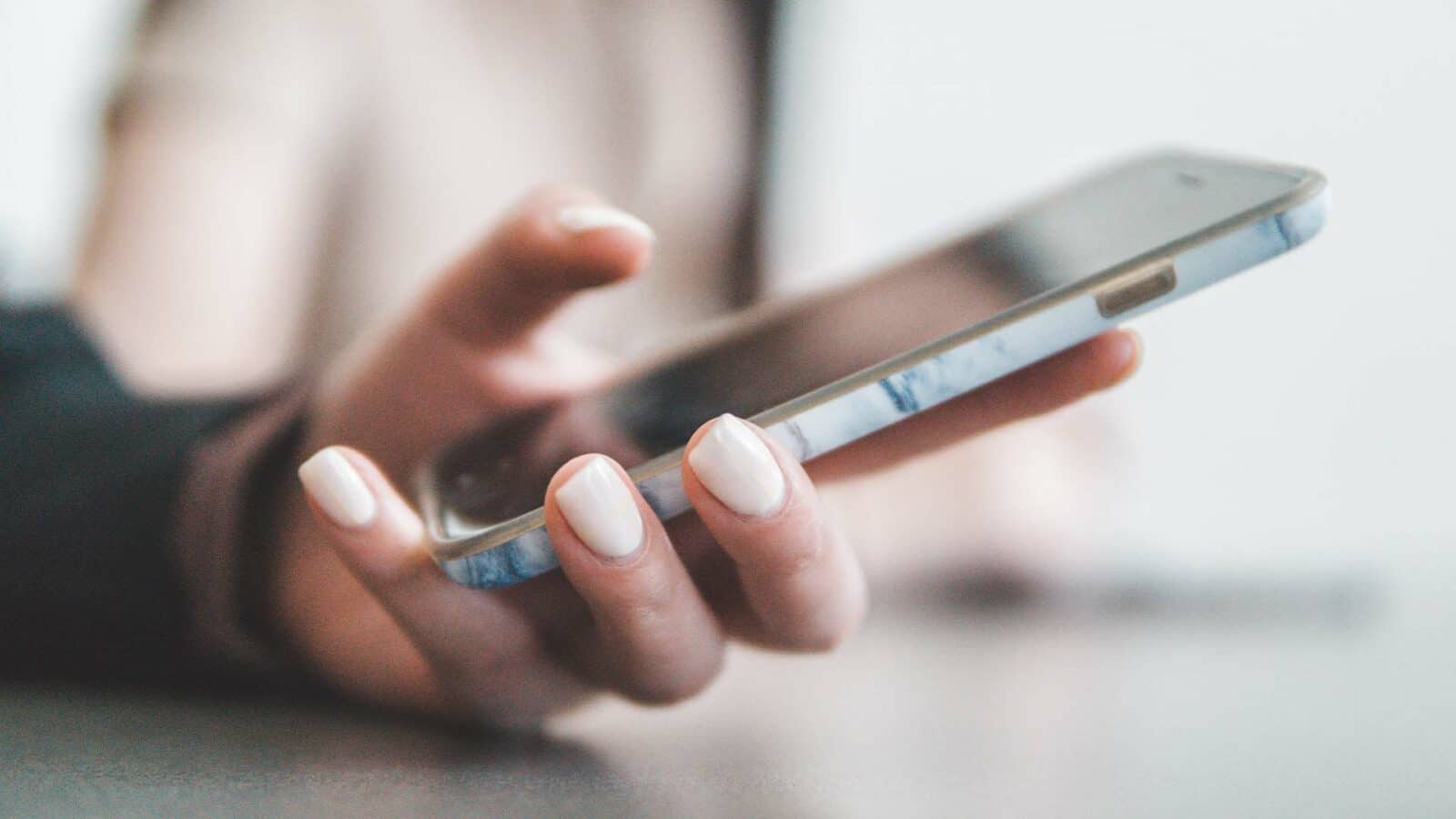 Une personne tient un téléphone portable.