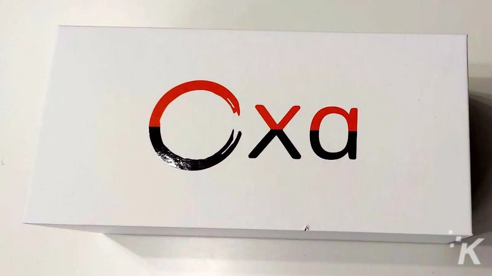 โลโก้พร้อมตัวอักษร 'Cxa' เป็นสีดำและสีแดง