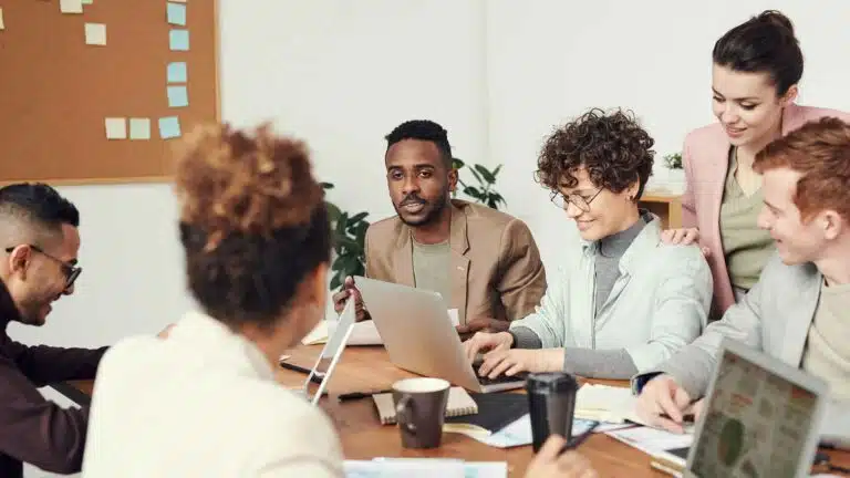 Pessoas em reunião para uma empresa de relações públicas com laptop.