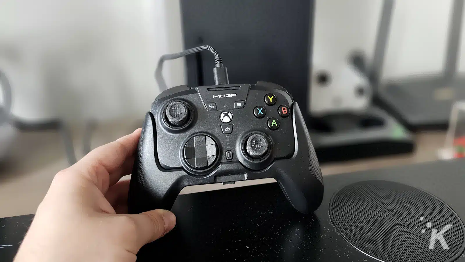 Mano che tiene un controller Xbox MOGA in ambienti chiusi.