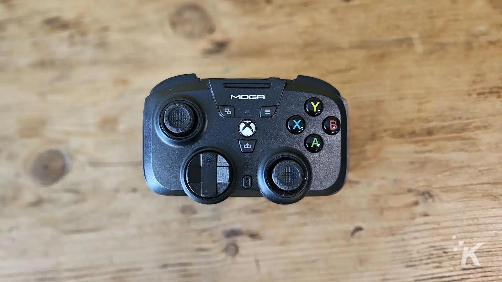 Controller di gioco MOGA Xbox su superficie in legno.