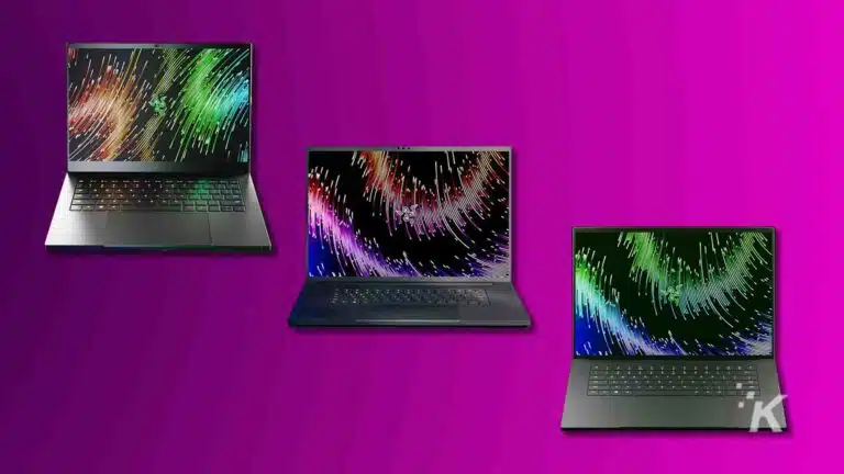 Três laptops com protetores de tela coloridos sobre fundo roxo.