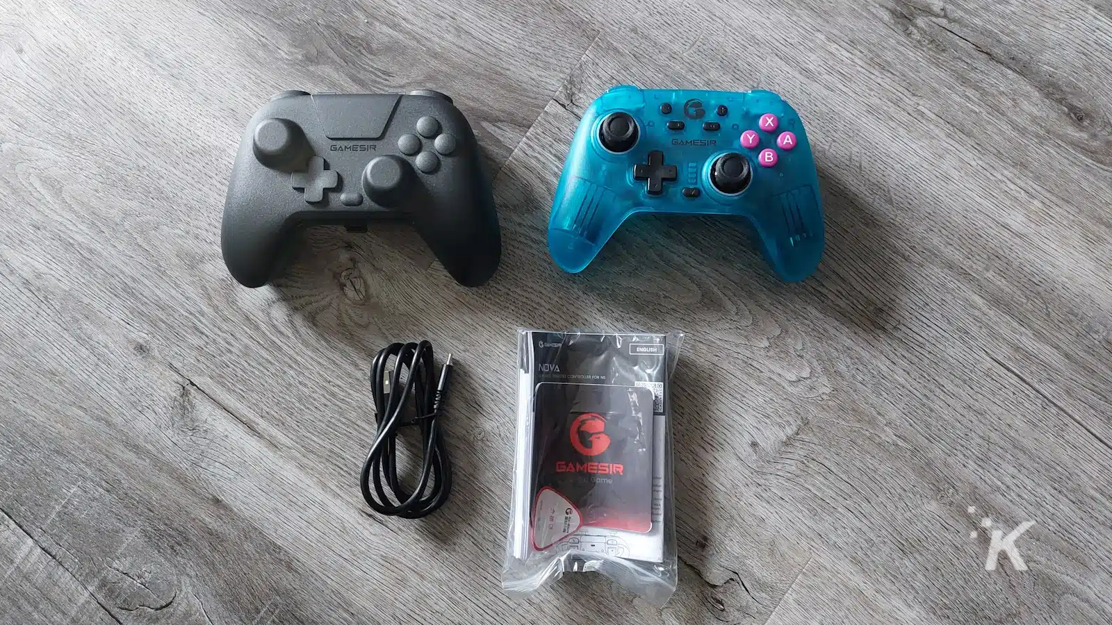 Zwei GameSir-Controller und Zubehör auf Holzboden.