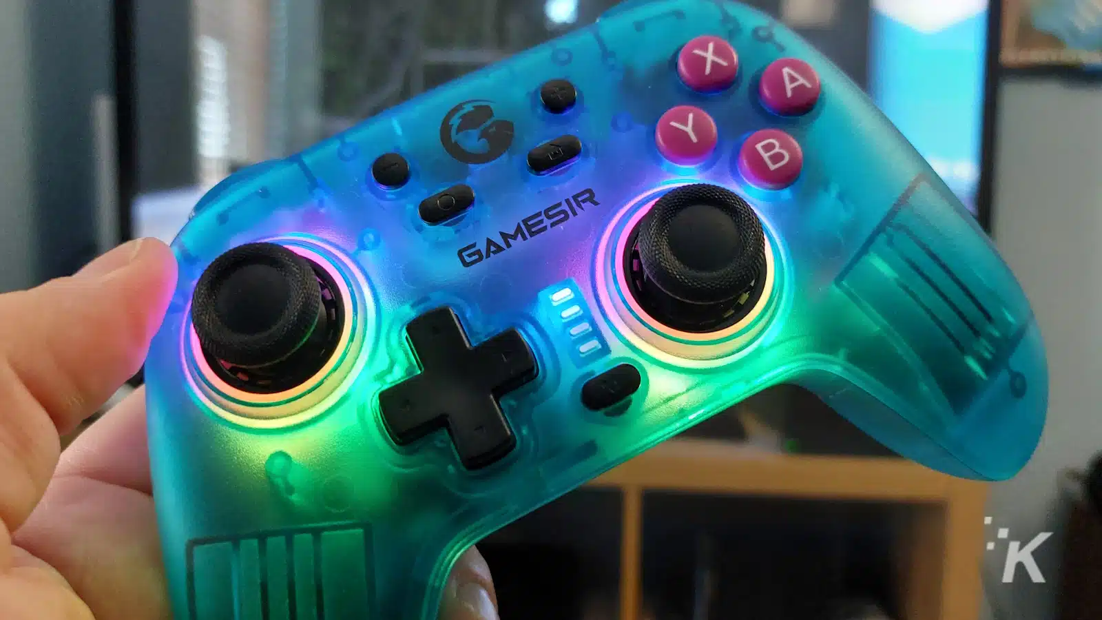 Hand hält beleuchteten blauen GameSir-Gaming-Controller.