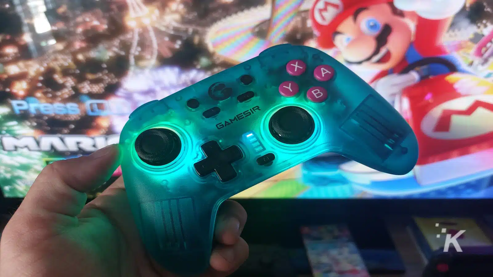 Manette Gamesir tenue devant l’écran de jeu de Mario.