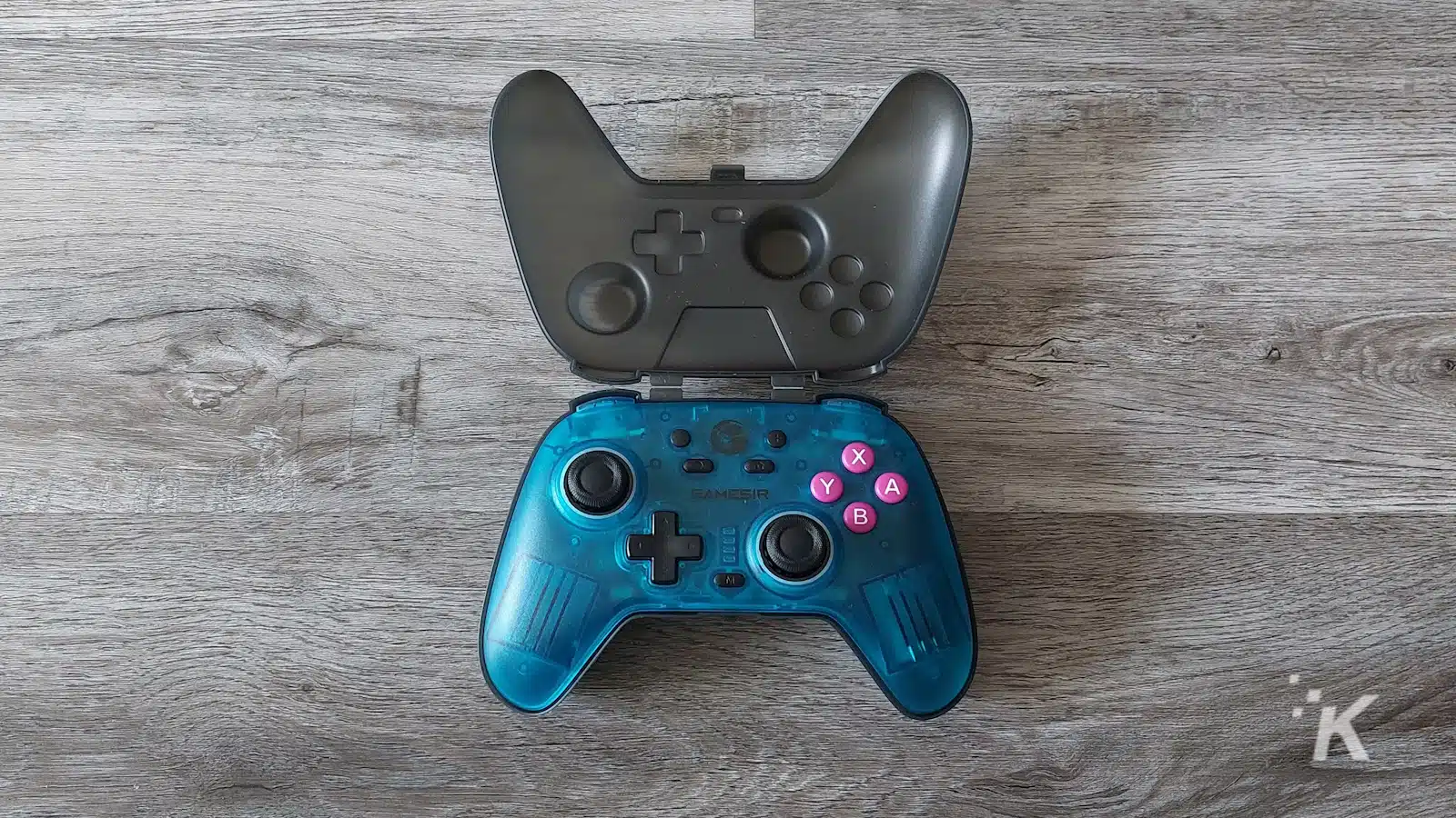 Blauer kabelloser Gamecontroller mit offenem Gehäuse auf Holz.