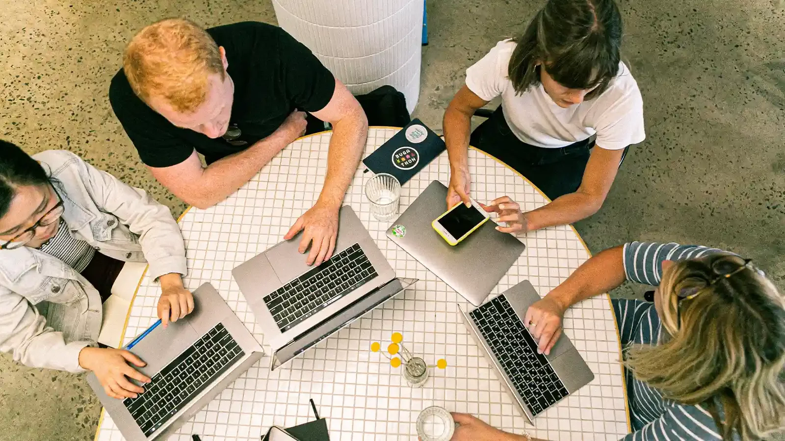 Influenciadores em torno de uma mesa em laptops