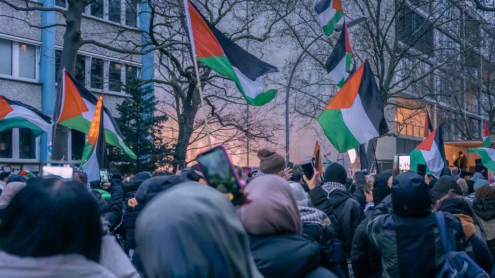 抗議活動中にパレスチナ国旗を掲げる群衆。