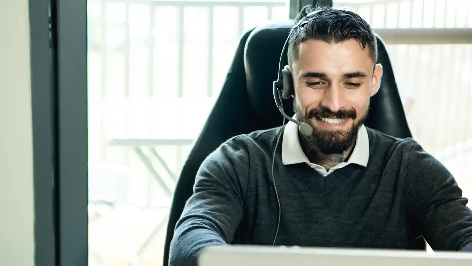 Mann mit einem Headset am Computer