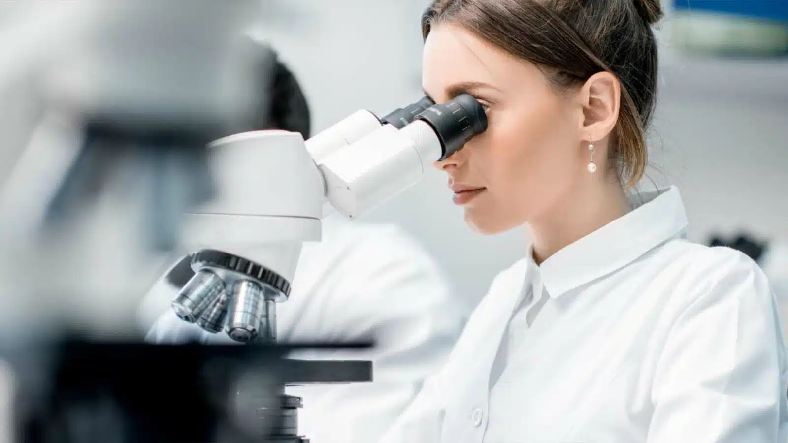 mujer usando microscopio