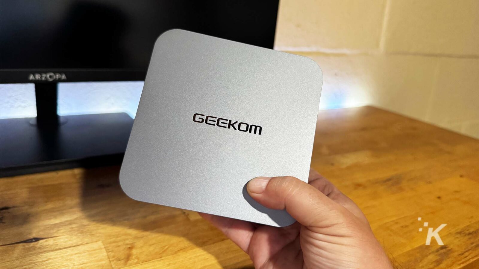 Geekom ミニ PC をモニターの近くに持つ手