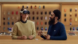 Сотрудник Apple Store показывает покупателю, как пользоваться гарнитурой Vision Pro.